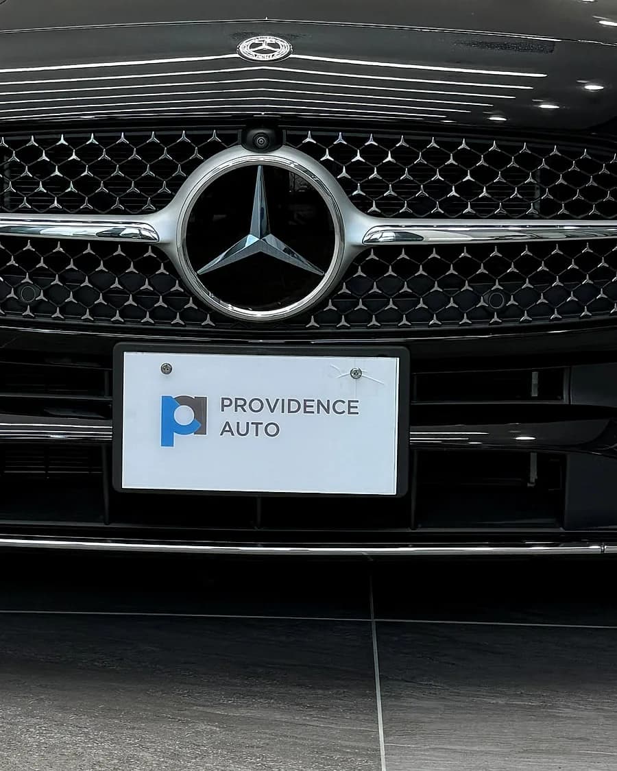 A Mercedes-Benz grille and star with a Providence Auto plate below it